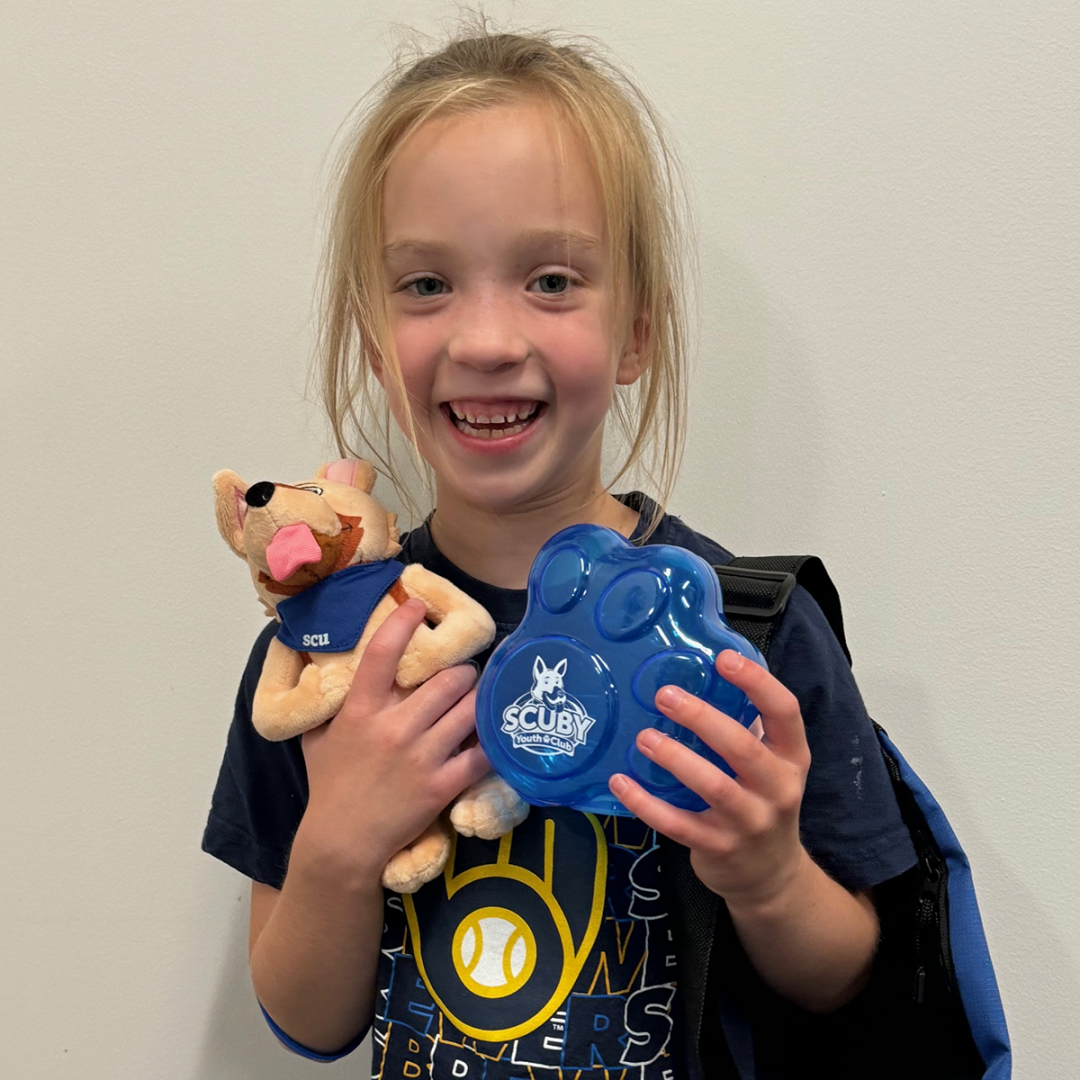 Child holding piggy bank and Scoby doll